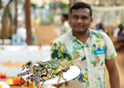 Munjoh staff-a waiter holding a plate with a large crab