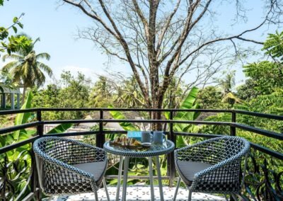 Private balcony with table, chairs and tropical hillside view at the Emerald Suite, Munjoh Island House