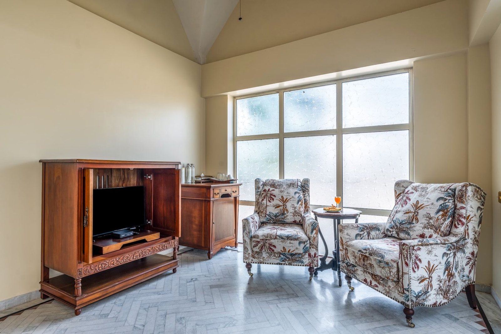 Window-side seating area with floral armchairs in the Jade Suite at Munjoh Island House
