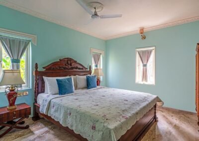 Blue bedroom with carved wooden bed in Kohinoor Residence at Munjoh Island House